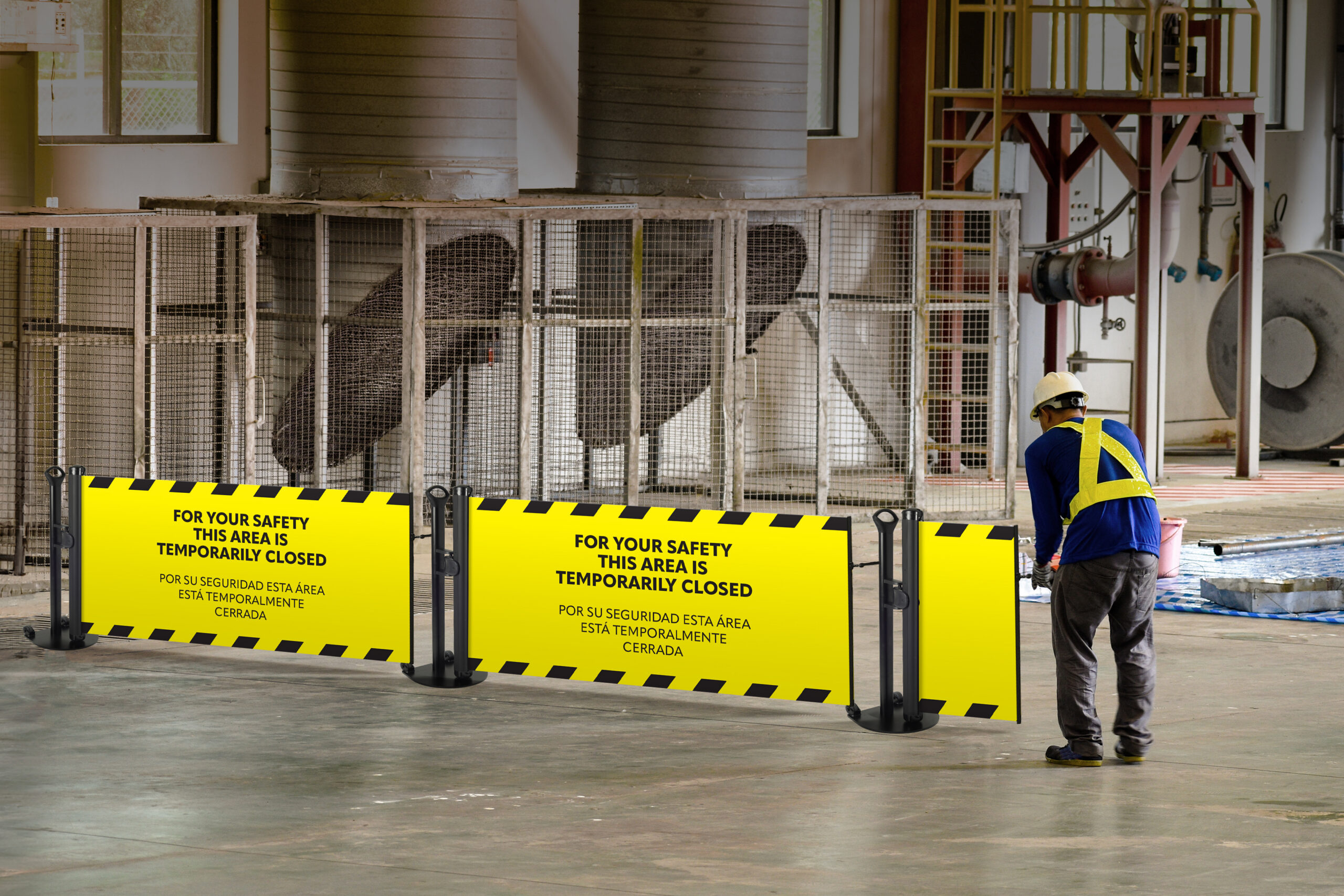 Worker stretching the red white warning tape to the pole at construction site.Red and white Hazardous restricted area tape at construction area of factory to mark territory works.